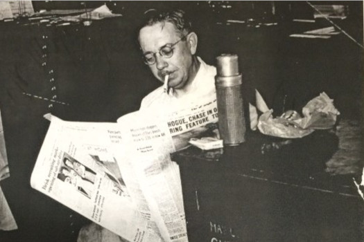 Elmer Lore, Sr. reading a newspaper.